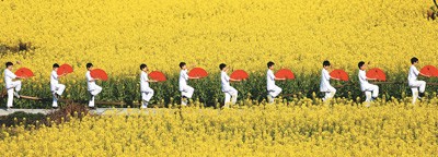  3月26日，在重庆市黔江区太极镇李子村高标准油菜花田里，该镇中心学校师生在展示太极扇。杨 敏摄（人民视觉）