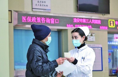江苏淮安，护士向就诊者解答医保报销流程。赵启瑞摄/光明图片