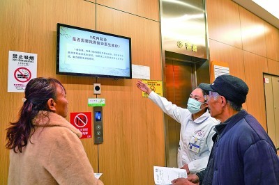 四川成都，医院导诊人员（右二）向患者解释“一次挂号管三天”惠民政策。 新华社发