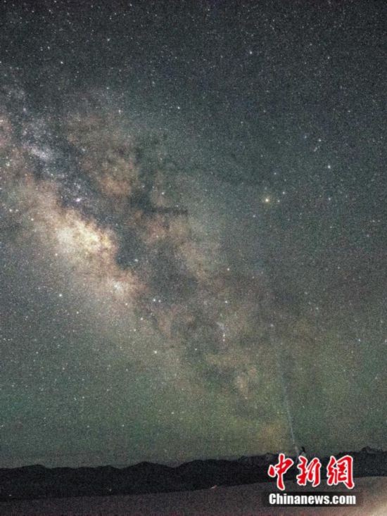 图为6月20日晚游客在西藏阿里暗夜公园，与银河“合影”。曹枝清 摄