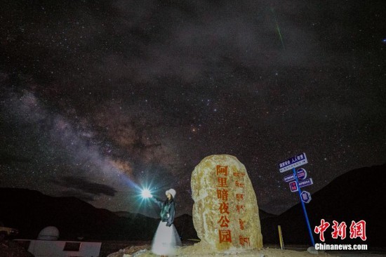 图为6月20日晚，游客“打卡”西藏阿里暗夜公园，天上是银河与流星（右上角）。曹枝清 摄