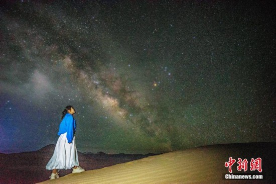图为6月20日晚，游客在西藏阿里暗夜公园与银河“合影”。曹枝清 摄