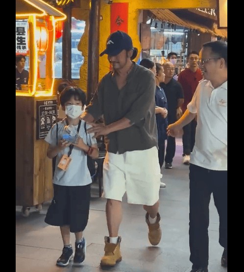 吴京携儿子南宁撸串！鸭舌帽配小辫造型随性，父子撸串画面超接地气