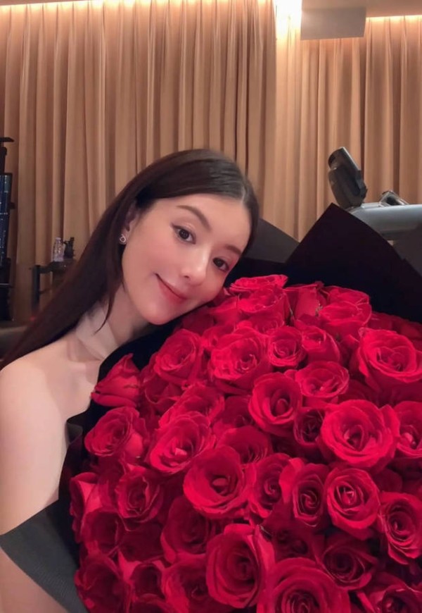 方媛抱着玫瑰花合影，美貌养眼。