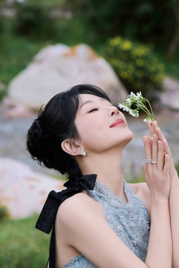 搜狐娱乐讯 近日，杨紫的一组美照爆出，图中，杨紫身着浅蓝色长裙，手捧小花轻嗅，妆容精致，优雅恬静。
