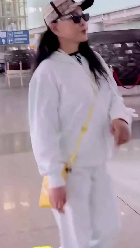 刘晓庆穿白色运动套装现身机场，神采奕奕显活力