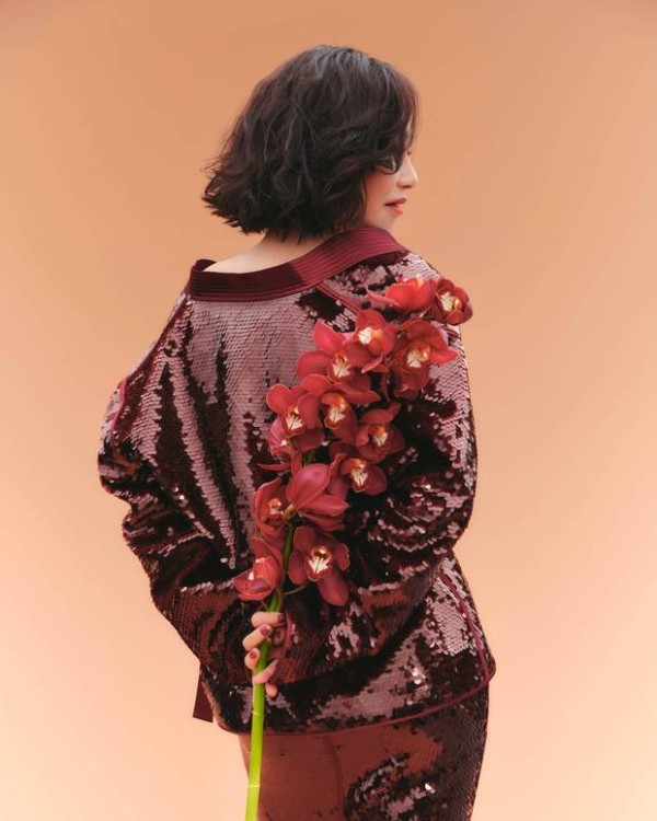 惠英红手持红花,背影窈窕。