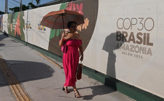 2025年11月4日，在巴西北部帕拉州贝伦市，一名女子从贝伦城市公园外《联合国气候变化框架公约》第三十次缔约方大会（COP30）的标识前经过。新华社发（卢西奥·塔沃拉摄）