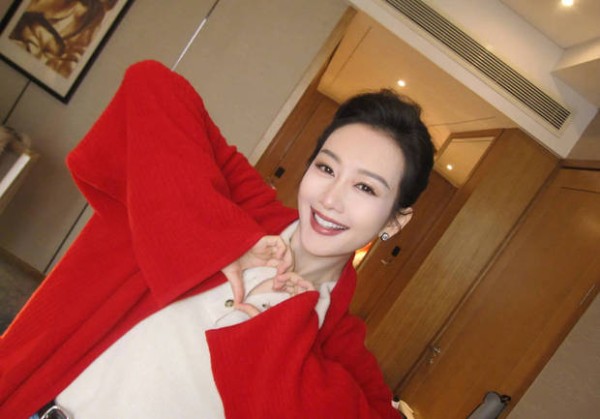 搜狐娱乐讯 25日，王鸥在社交平台上晒出一组美照，她身穿大红外套明艳动人，对着镜头甜笑比心十分养眼。