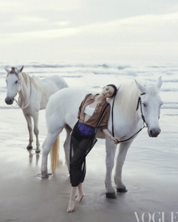 杨幂轻靠白马身侧，姿态放松自然。