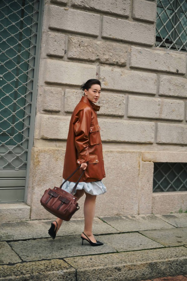 搜狐娱乐讯 近日，贾玲亮相米兰时装周美图释出。图中，她棕色皮衣搭配浅蓝裙摆混搭感十足，松弛又随性。