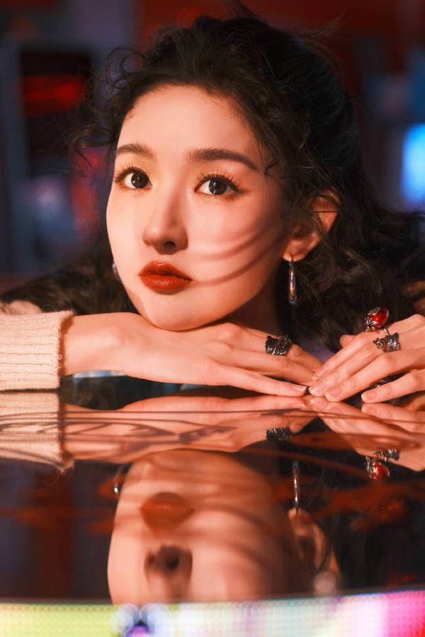 王玉雯伏在反光台面，光影在脸上流转，清冷魅惑。