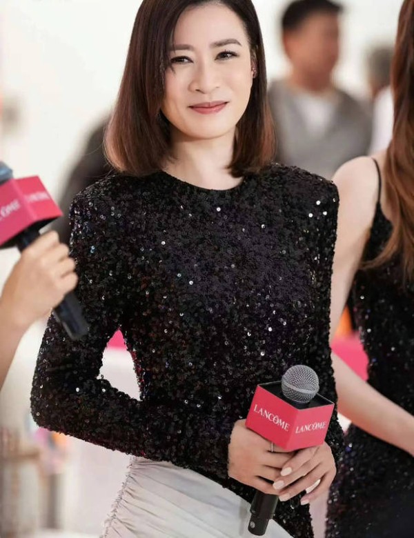 佘诗曼浅笑，神态优雅动人。