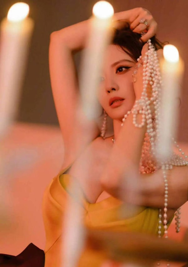 张萌撑腮凝望镜头，烛光氛围慵懒松弛。