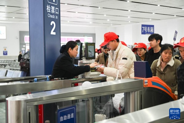 2月22日,来自黔东南州各区县的外出务工人员及家属在凯里南站检票进站。新华社发(邵健摄)