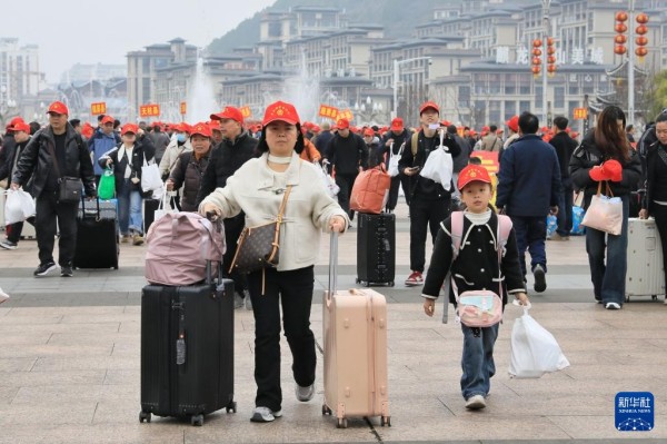 2月22日,乘坐返岗务工专列的务工人员及家属在凯里南站广场准备进站。新华社发(王波摄)