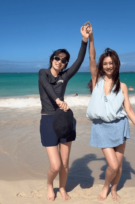 二人在海边开心玩耍，十分惬意。