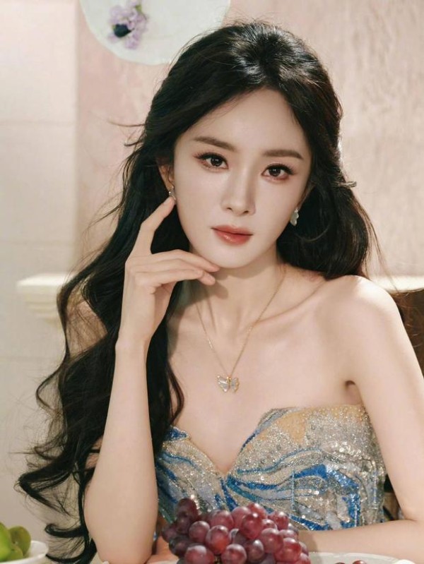 杨幂托腮，卷发灵动显温柔。