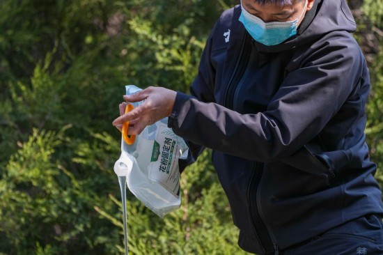 3月15日，在北京地坛公园，工作人员在向洒水车内添加花粉固定剂。新华社记者 鞠焕宗 摄