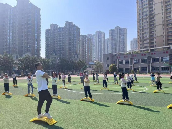 南昌市珠市学校云飞路校区的体育课上,学生们在操场上跟着老师进行平衡性训练。受访单位供图