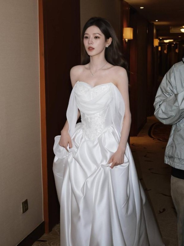 张予曦一袭缎面白纱抹胸裙，提裙迈步，清冷又优雅，宛如从童话走出的公主。