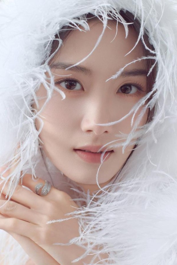 卢昱晓裹羽毛,眉眼灵动。