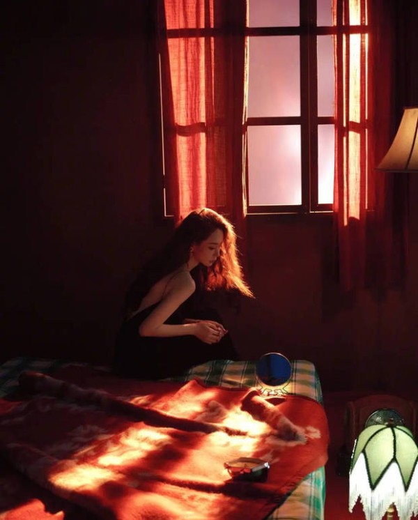 戚薇窗边静坐，逆光勾勒清冷氛围感。