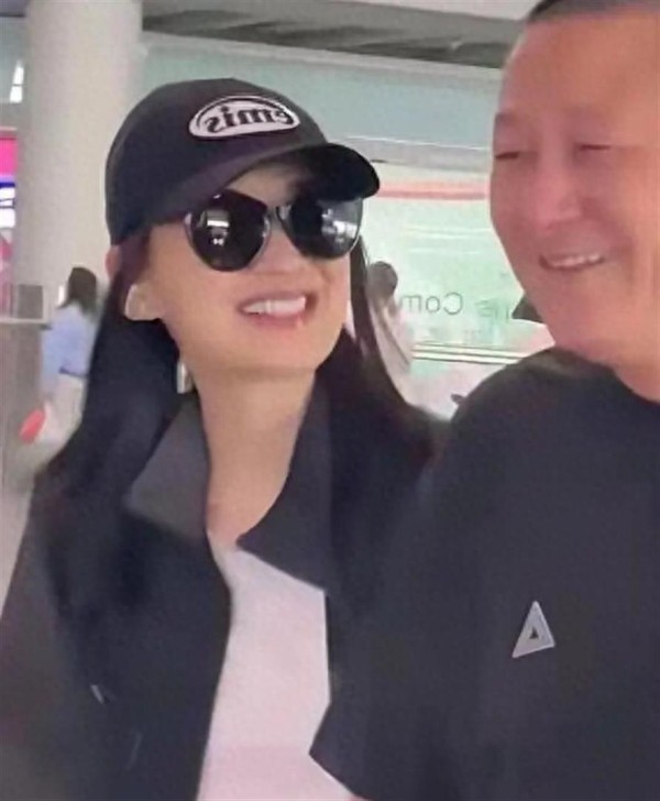 曾剑机场接梅婷回京，一身黑色老人味特重，俩人牵手像父女