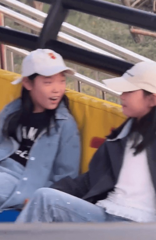 小酒窝与好友在游乐设施上。