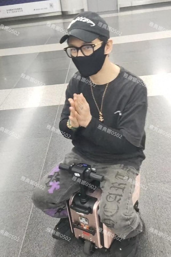 黄晓明北京机场再引争议，骑粉箱脚踩厚底鞋，人到中年图什么