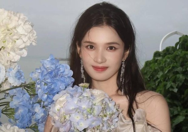 搜狐娱乐讯 7月21日，张婧仪晒出新剧《野狗骨头》的片场花絮照，手捧绣球花笑容甜美。