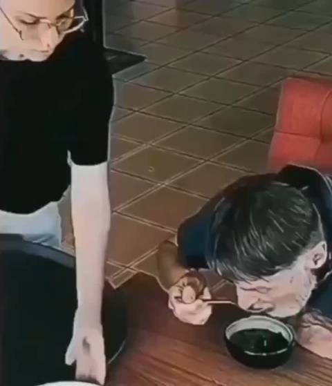 一个无家可归的家伙在吃剩饭，女服务员把剩饭拿走，给他端上了新鲜的食物