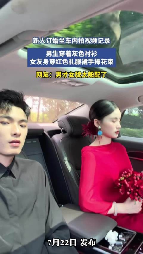 新人订婚坐车内拍视频记录,男生穿着灰色衬衫,女友身穿红色礼服裙手捧花束!